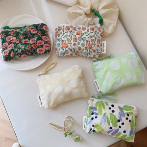 Vue à plat de petites pochettes en coton avec fermetures éclair et imprimés floraux