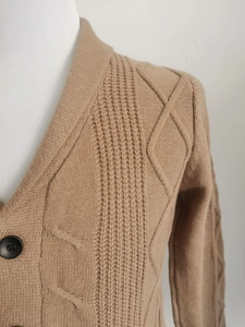 Nahaufnahme der kamelfarbenen Strickjacke mit Rippmuster und einreihiger Knopfleiste