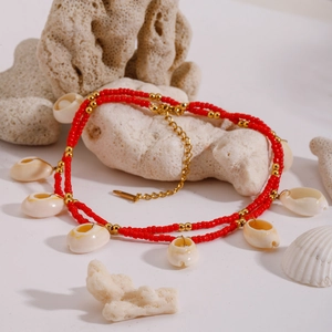 Double-layer ocean style necklace with red beads and white shell pendants on white background
