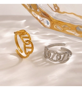 Macro view of gold and silver pig nose link rings on a warm rippled background