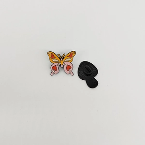 Colorful butterfly enamel pin badge with heart patterns on vibrant orange wings