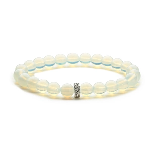 Close-up of matte white beads with a textured silver metal spacer bead on a minimalist bracelet