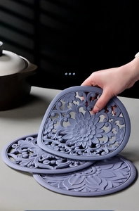 Detail of grey-purple silicone heat resistant mat with Chinese floral embossed pattern