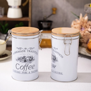 Close-up of white airtight tin canisters for coffee and sugar with wooden lids