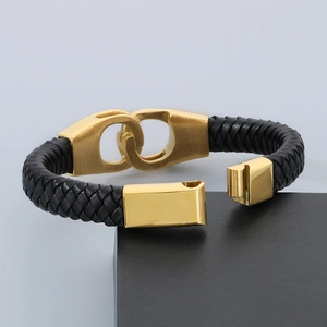 Detail of men's black braided leather bracelet with gold-plated stainless steel clasp