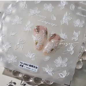 Detail showing 5D embossed white flower nail stickers with 3D texture and gold foil