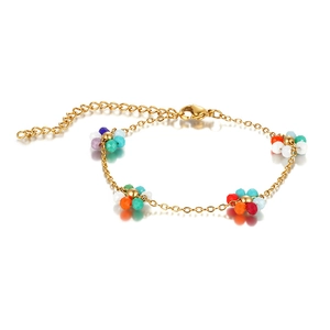 Detail of bohemian floral beaded bracelet with gold chain and colorful glass beads