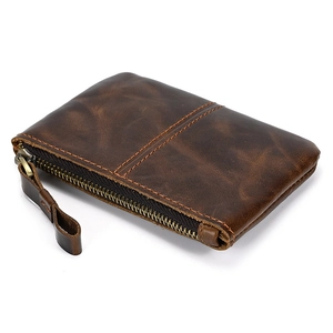 Close-up of dark brown genuine leather coin purse with vintage texture and metal zippers