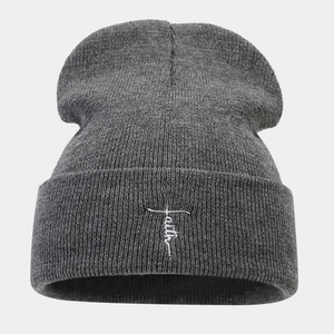 Detail of grey ribbed knit beanie featuring white faith cross embroidery on cuff