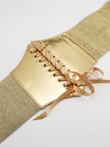 Detail of golden elastic waist belt featuring metallic front panel and lace-up ribbon closure