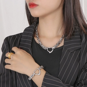 Detail of silver heart charm on Byzantine style stainless steel necklace and bracelet set