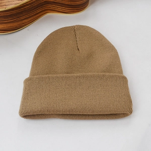 Gros plan sur la texture en maille fine et le tissu marron kaki de ce bonnet chaud