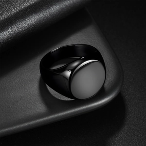 Minimalist black stainless steel signet ring with a polished finish and round flat top