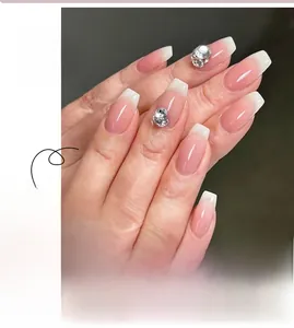 Detail of pink gradient press-on nails with white French tips and luxury rhinestones