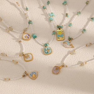 Colliers de perles sur le thème marin avec pendentifs baleine et soleil dorés
