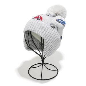Detailed knit texture and earflaps of kids' winter hat with car pattern and pom-pom
