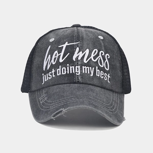 Detail of embroidered hot mess quote on washed denim cap with breathable mesh and distressed brim