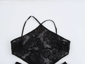 Detailed view of black lace hollow-out dress showing floral patterns and cross straps