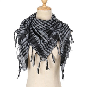 Detail of black and grey checkered keffiyeh scarf with tassels on a mannequin torso