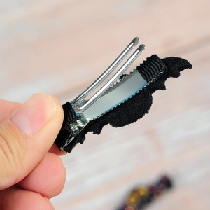 Detail of Halloween bat hair clip showing black felt wings and rib ribbon wrapped metal grip