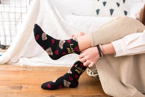 Close-up of black cotton mid-calf socks featuring brown bear and LOVE ME embroidery