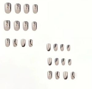 Detailed view of gray and coffee marble pattern false nails with gold foil and glitter
