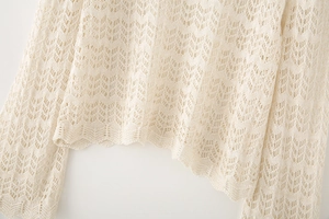 Detailed macro shot of beige crochet knit fabric featuring intricate openwork textures