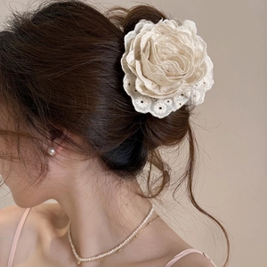 Elegant cream lace rose hair claw clip shown on a low bun hairstyle for women