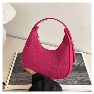 Detail showing the magenta crocodile texture faux leather and golden zipper on the bag