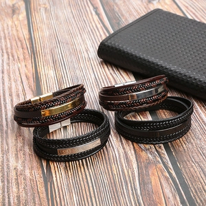 Macro detail of braided leather bracelets with stainless steel clasps on wood table