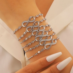 Detail of silver infinity bracelets set with zircon and family inscriptions on wrist