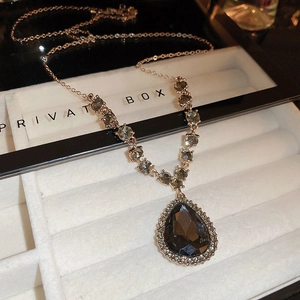Détail d'un collier avec pierre précieuse en forme de poire dans son écrin de luxe