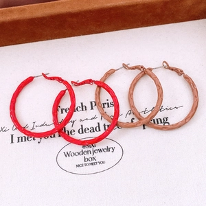 Detail showing red and light coffee textured hoop earrings with hammered metal finish
