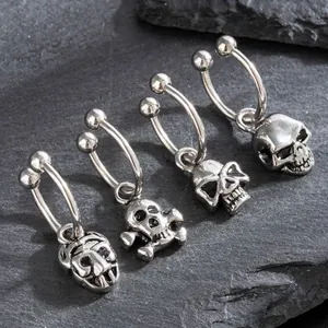 Titanium steel skull hoop earrings in silver punk style on a dark stone background
