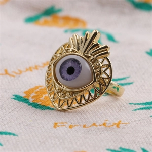 Close-up of vintage gold plated ring with purple zircon evil eye inlay and engraved detail