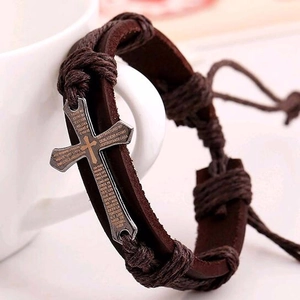 Handwoven brown leather bracelet with a metal cross featuring Spanish prayer engraving