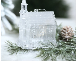 Gros plan d'une décoration de maison de Noël transparente sur des aiguilles de pin