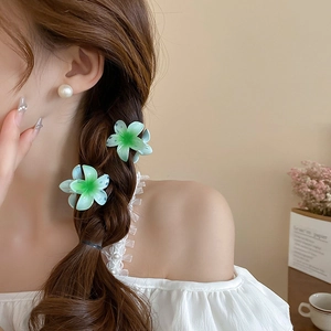 Detail of sweet gradient sunflower hair claw clips styled in a French braid hairstyle