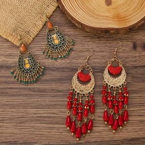 Boucles d'oreilles bohèmes avec fleurs en bronze et pompons de perles rouges sur bois