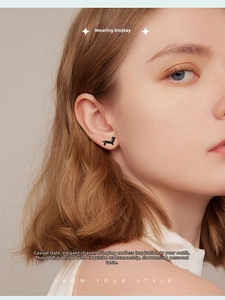 Close-up of cute black dachshund stud earrings in s925 silver on a model ear