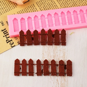Pink silicone garden fence mold with finished chocolate fence on vintage background