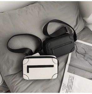 Detail of minimalist rectangular crossbody bags in black and cream with wide nylon straps