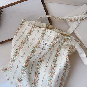 Close-up of floral cotton tote bag featuring vintage fabric label and soft texture