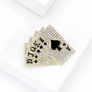 Macro shot of gold poker royal flush brooch featuring sparkling rhinestones and black enamel