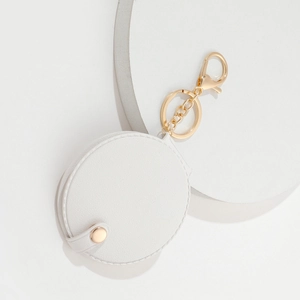 Detailed top view of white round PU leather keychain mirror on a minimalist background