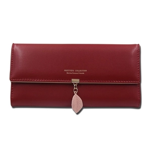 Close-up of red long wallet for women featuring a flap closure and pink leaf pendant