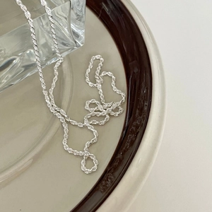 Elegant 925 sterling silver rope chain necklace with a textured weave on a ceramic plate