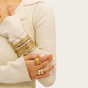 Gold stainless steel jewelry set featuring layered bracelets and geometric rings for women