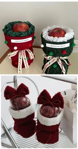 Detail of Christmas apple gift bags featuring red plush boots and knit covers with bows