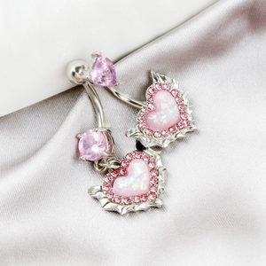 Close-up of pink heart opal belly ring with zircon accents on a grey silk fabric